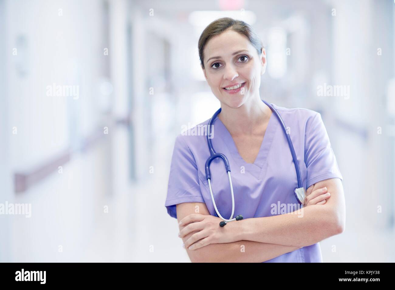 Krankenschwester trägt Lila einheitliche lächelnd in Richtung Kamera, Portrait. Stockfoto