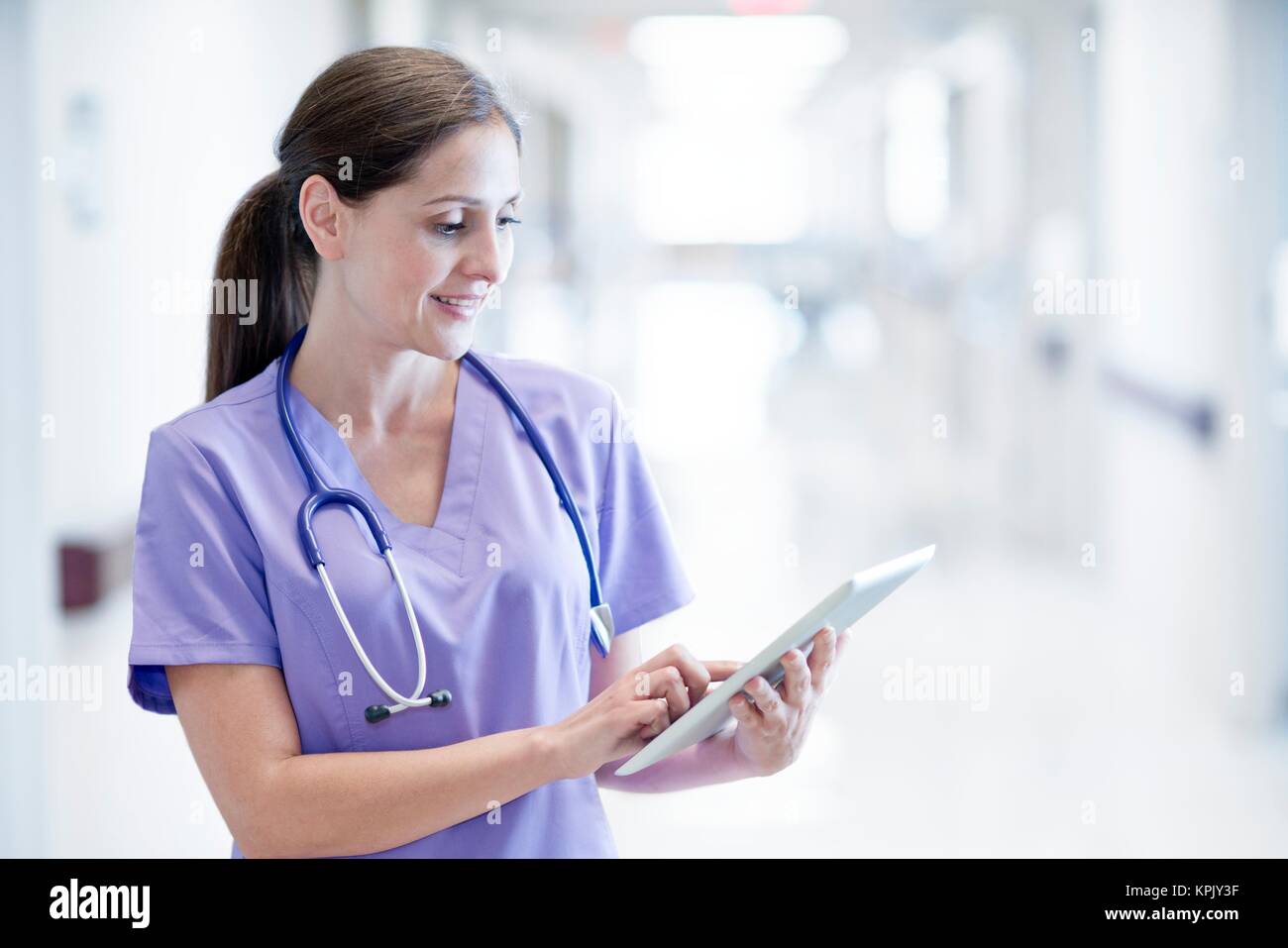 Krankenschwester trägt Lila einheitliche mit digitalen Tablet. Stockfoto