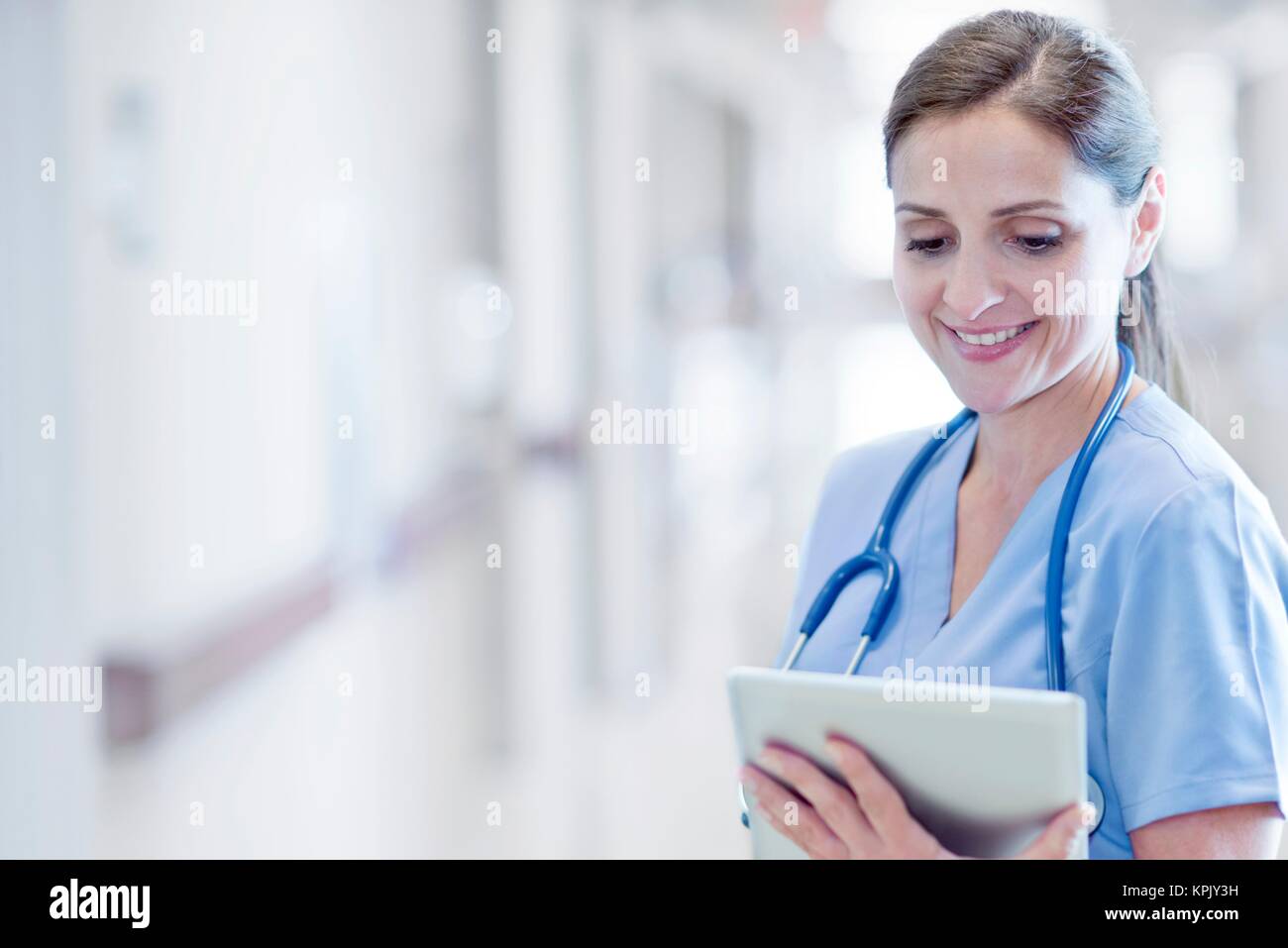 Krankenschwester trägt blaue Uniform mit digitalen Tablet. Stockfoto