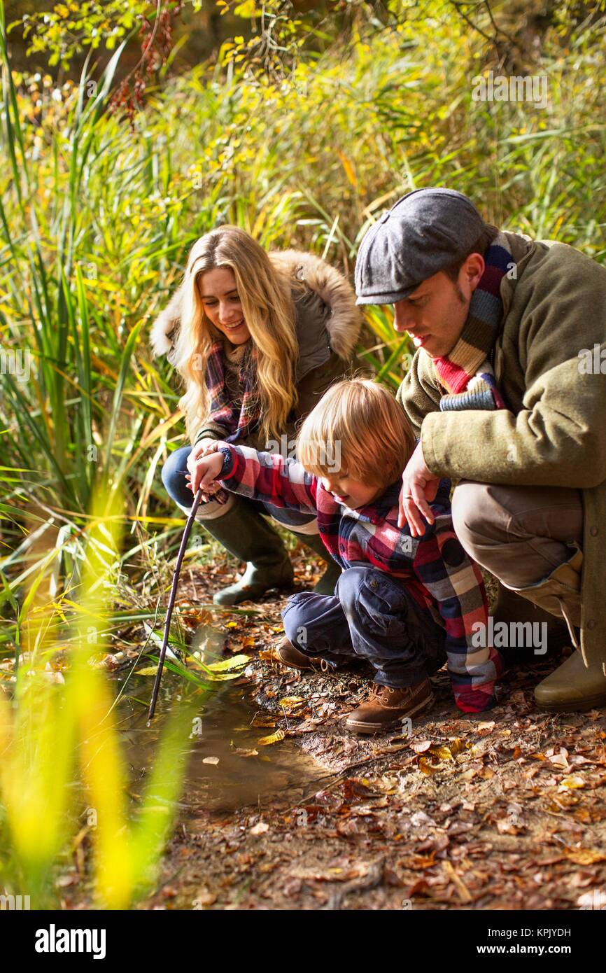 Familie Hockend von Teich und Suchen in das Wasser. Stockfoto