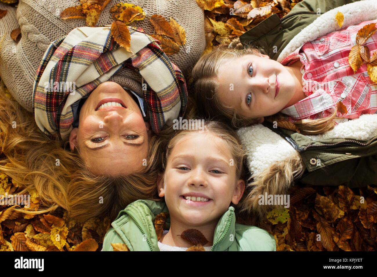 Familie liegend auf der Blätter im Herbst, Portrait. Stockfoto