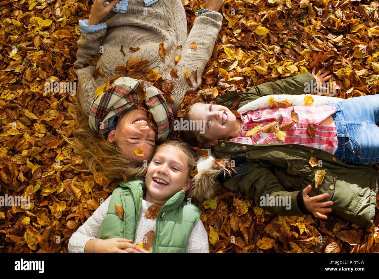 Familie liegend auf der Blätter im Herbst, Portrait. Stockfoto