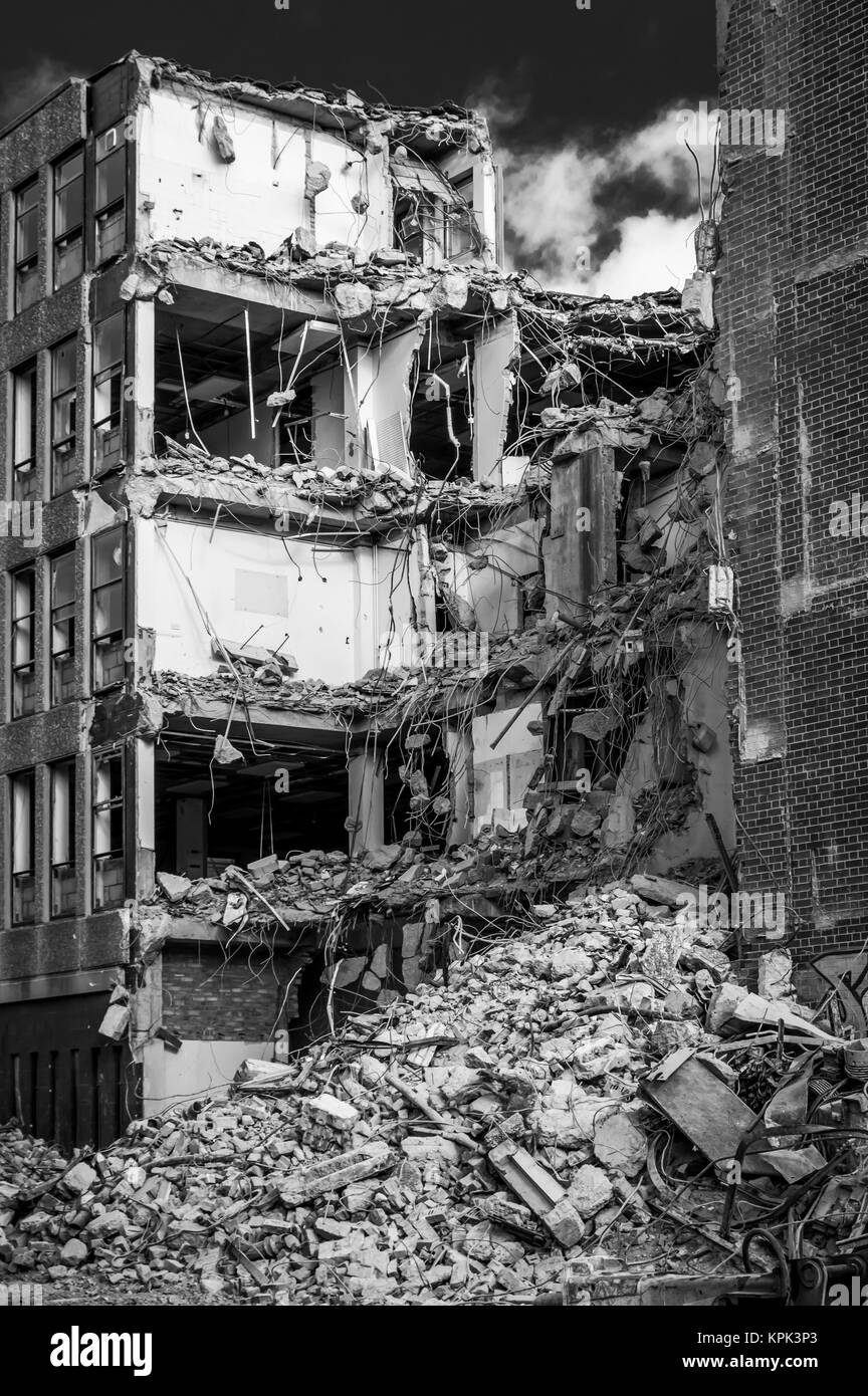 Ein Gebäude unter Abriss mit einem Haufen Schutt auf dem Boden und Etagen des Gebäudes ausgesetzt; Newcastle Upon Tyne, Tyne und Wear, England Stockfoto