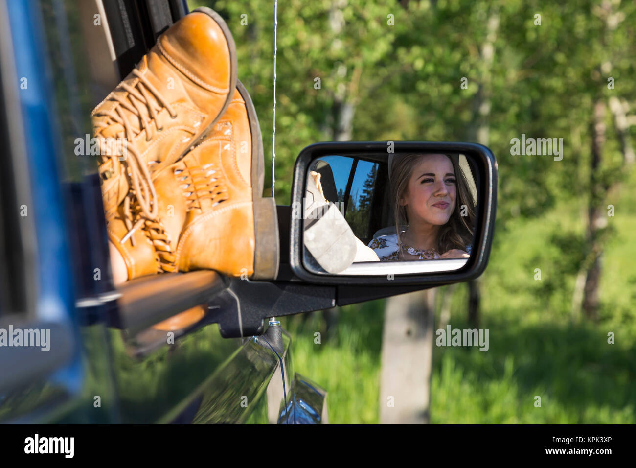 Einen weiblichen Fahrgast mit ihren Füßen aus dem Fenster des Fahrzeugs während einer Pause auf einem Road Trip; Edmonton, Alberta, Kanada Stockfoto