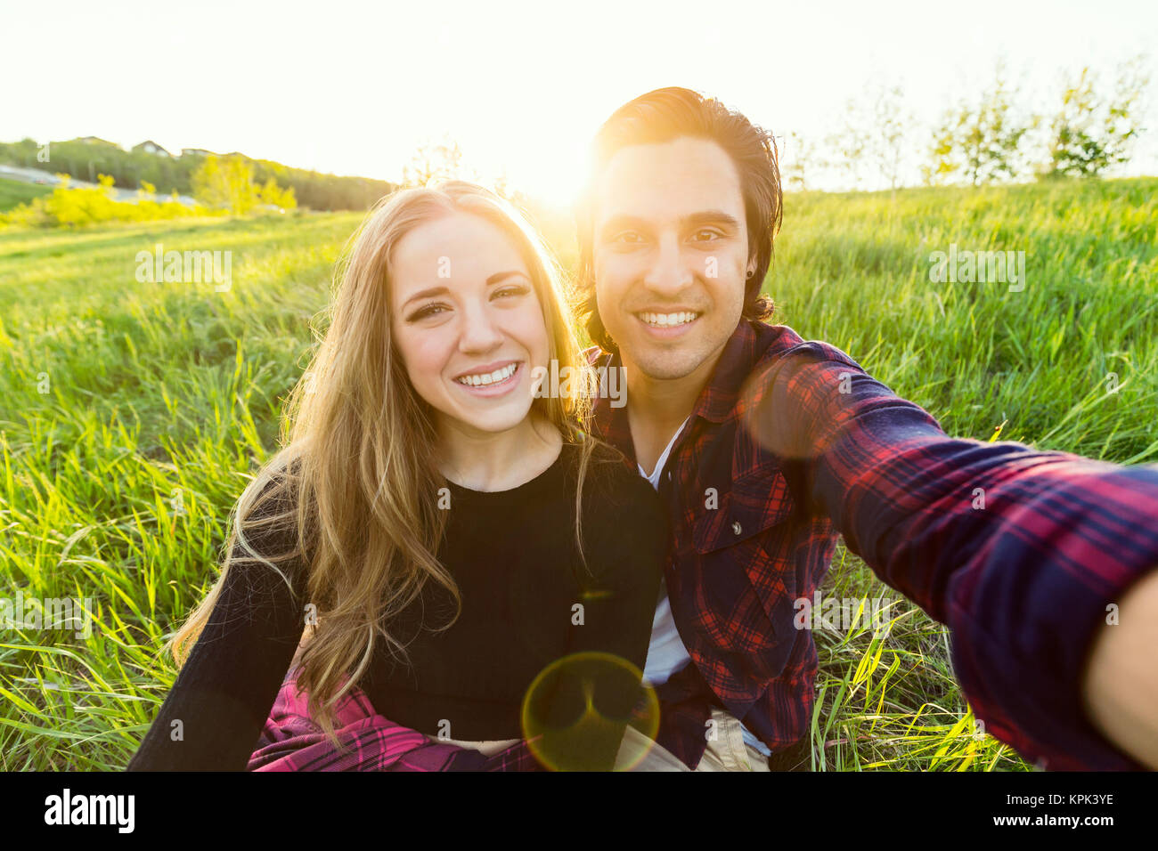 Junges Paar in einem Park für einen selbst posiert - Porträt mit ihrem Handy, Edmonton, Alberta, Kanada Stockfoto