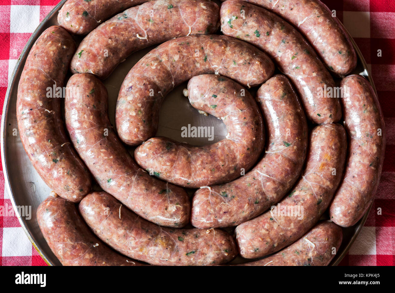 Nahaufnahme eines Kreises von rohe Würstchen auf einem runden kochen Fach auf einer rot-weiß karierte Tischdecke, Calgary, Alberta, Kanada Stockfoto