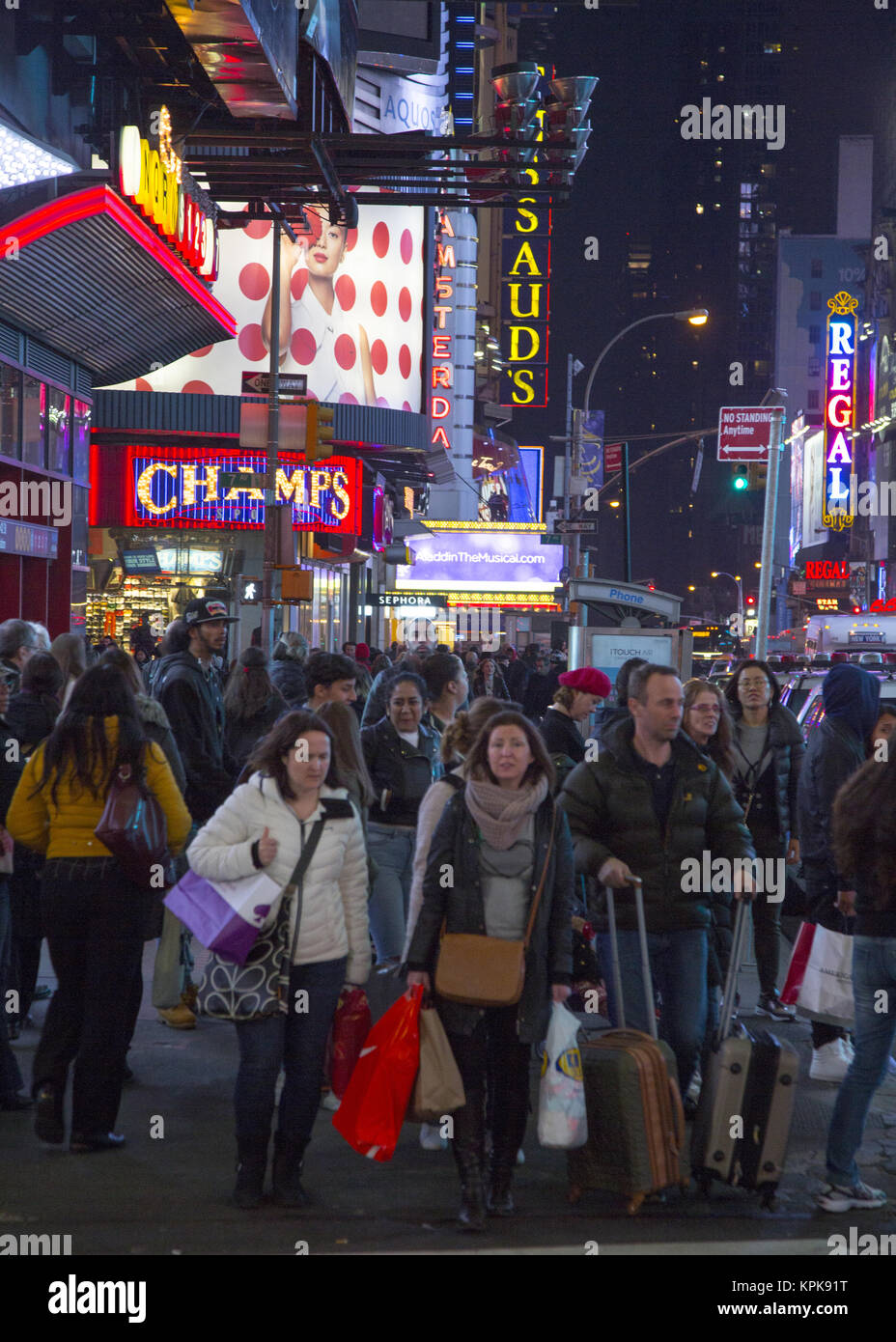 Massen von Touristen mit Gepäck und Einkaufstaschen Spaziergang auf der West 42nd Street in der Times Square Gegend während der Weihnachtszeit in Manhattan, New York City. Stockfoto