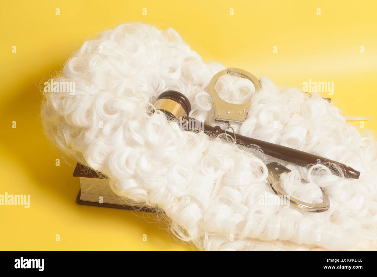Für Richter: Richter Perücke, handclufs, Richter Hammer, Buch auf gelbem Hintergrund Stockfoto