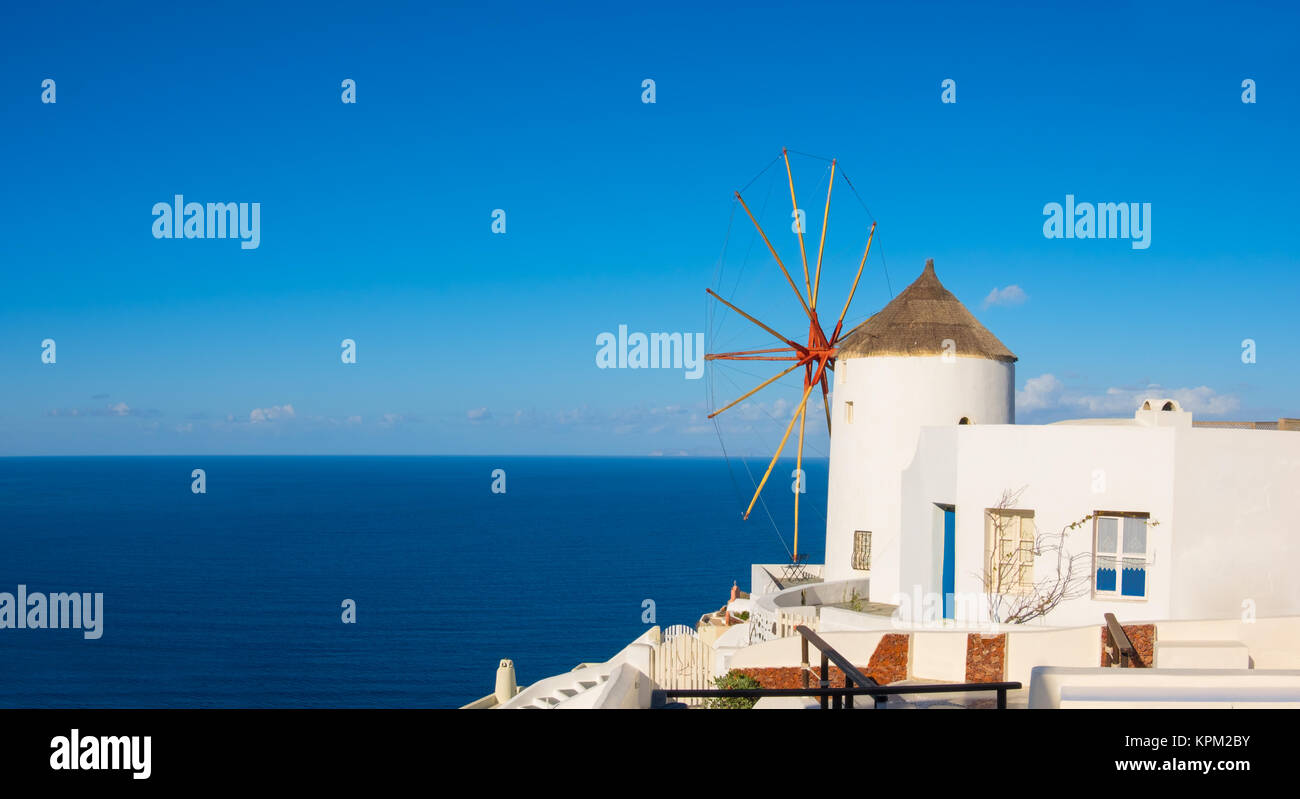 Santorini in Griechenland - traditionelle Windmühle und Apartments in Oia an einem sonnigen Tag, Panoramic Image. Stockfoto