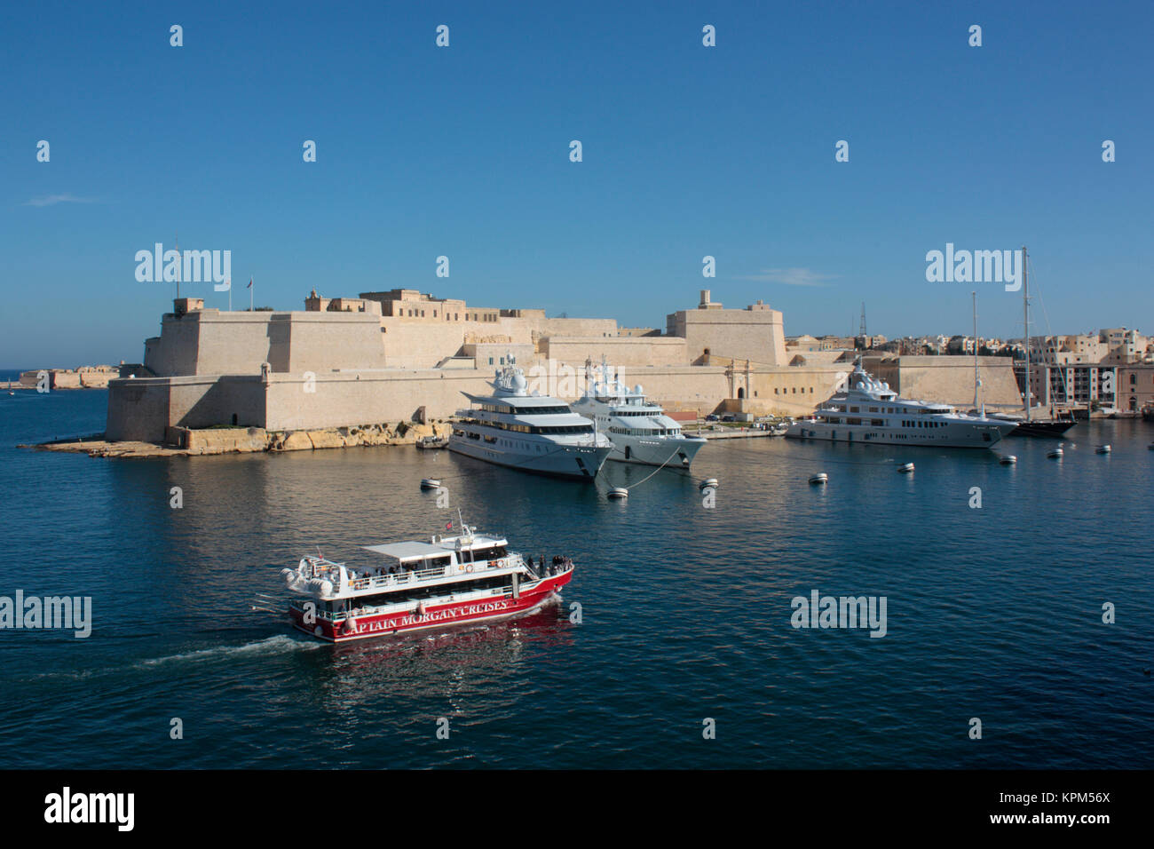 Grand Harbour Tour Boot vorbei an Fort St. Angelo, Malta, mit Touristen Sightseeing an Bord. Der Tourismus ist ein wichtiger Wirtschaftssektor in Malta. Stockfoto