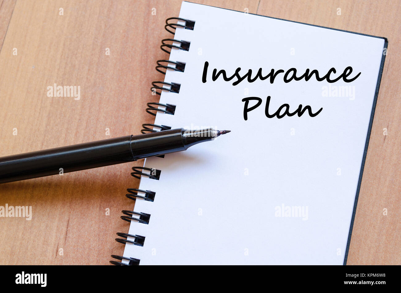 Insurance Plan schreibt am Notebook Stockfoto