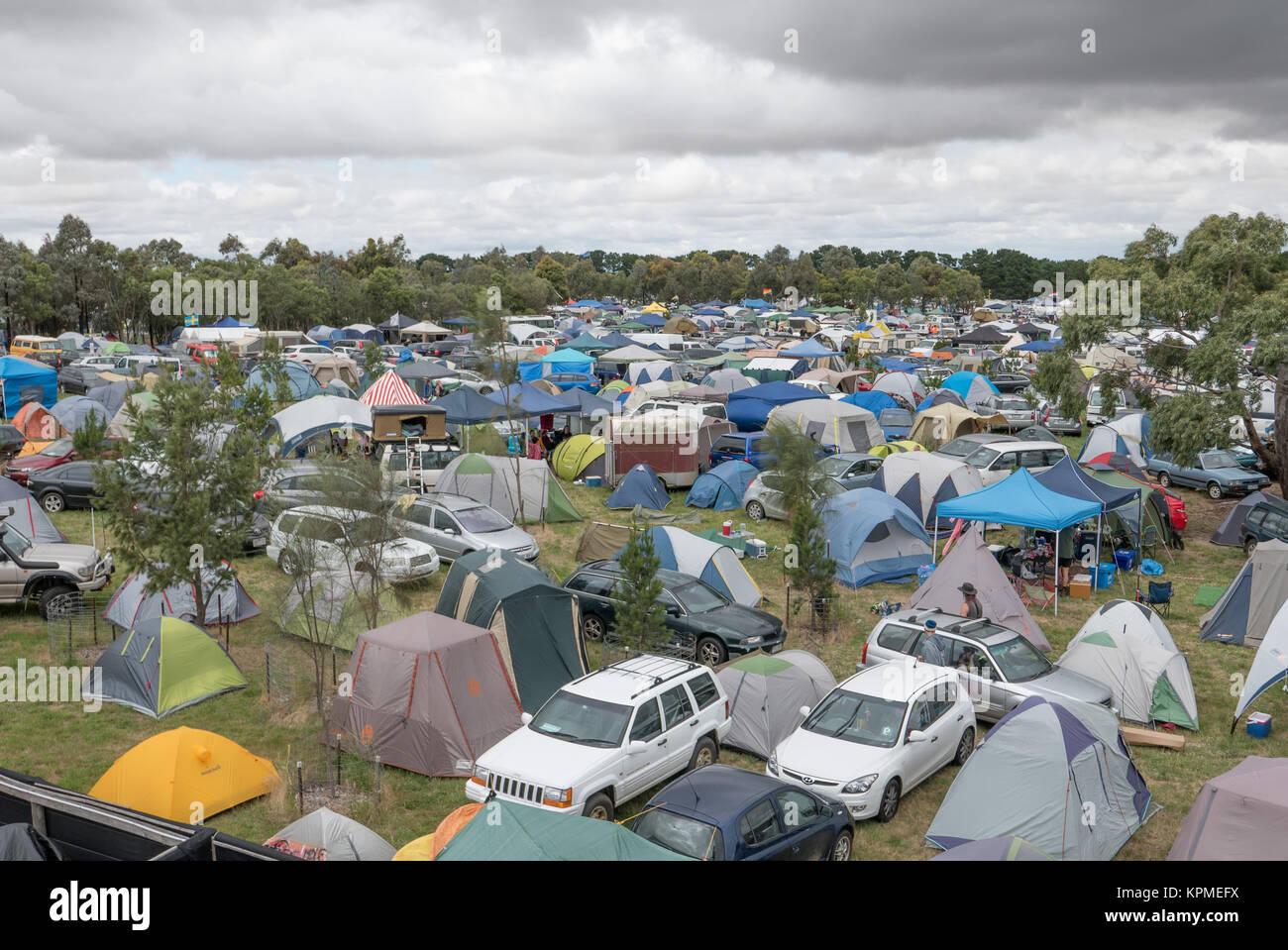 Luftaufnahme von sehr großen Music festival Camping mit Wohnwagen, Anhänger, Autos und Wald im Abstand. Stockfoto