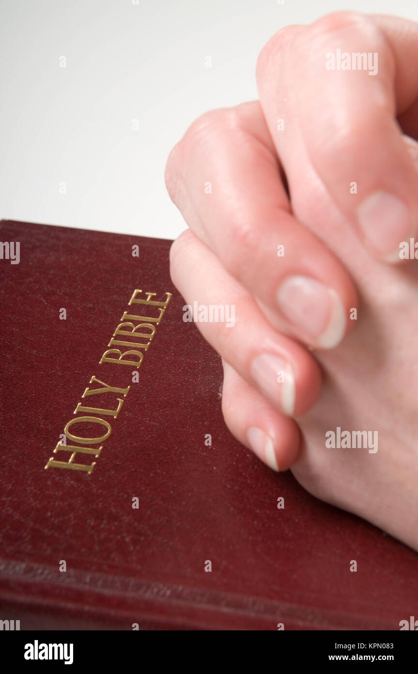 Betende Hände auf Bibel Stockfoto