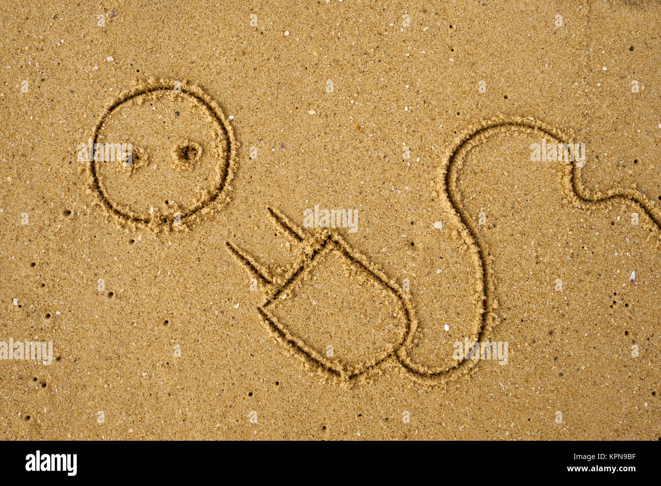 Netzstecker auf Sand gezeichnet. Stockfoto