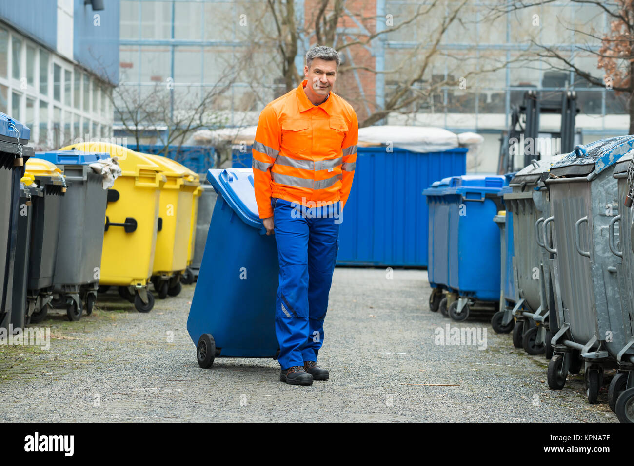 Männliche Arbeitnehmer gehen mit Mülltonne auf der Straße Stockfoto, Bild 168884787 Alamy