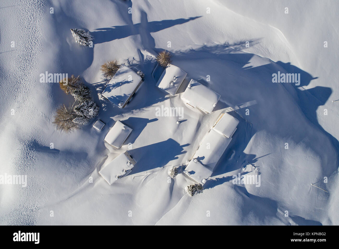 Kleine Hütten mit Schnee bedeckt, Ansicht von oben mit einer Drohne. Winterlandschaft Stockfoto