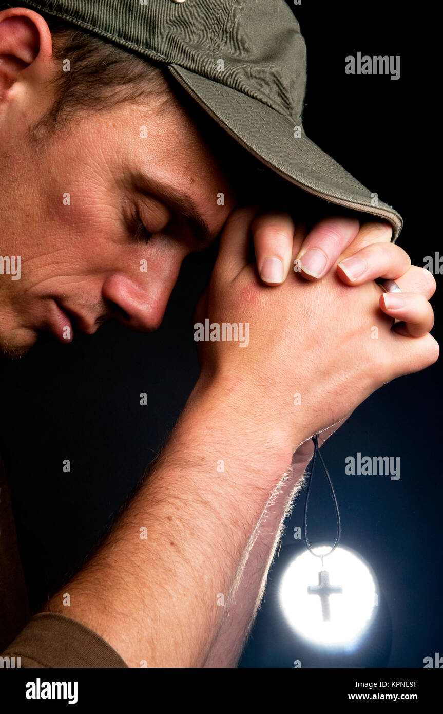 Beten Mann hält ein Kreuz Stockfoto