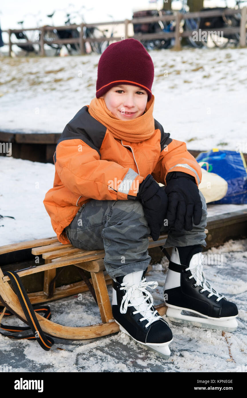 Kleiner Junge auf einem Schlitten Stockfoto