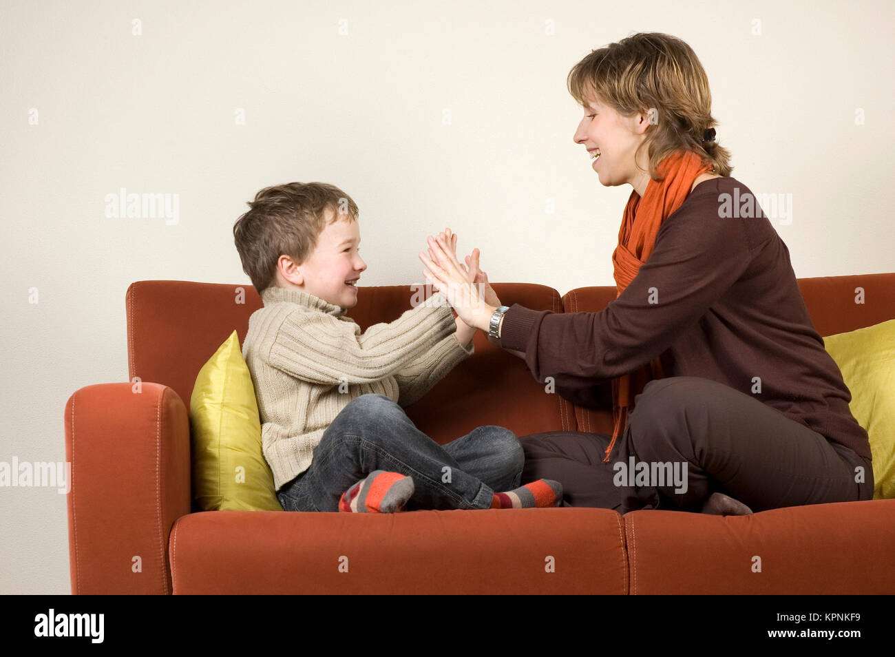 Mutter und Sohn spielen auf einer Couch Stockfoto