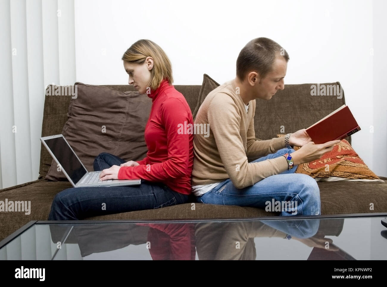 Model Release, Frau Arbeitet bin Computer, Mann liest Ein Buch - Frau mit Laptop, Mann liest ein Buch Stockfoto