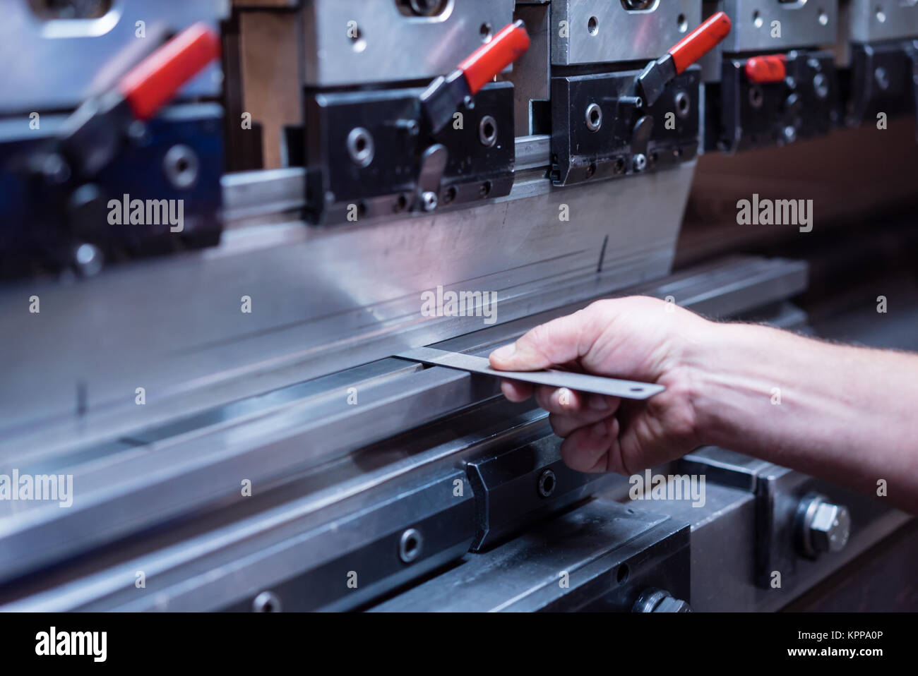 Der Arbeitnehmer mit der rechten Hand eine Metallplatte Stockfoto