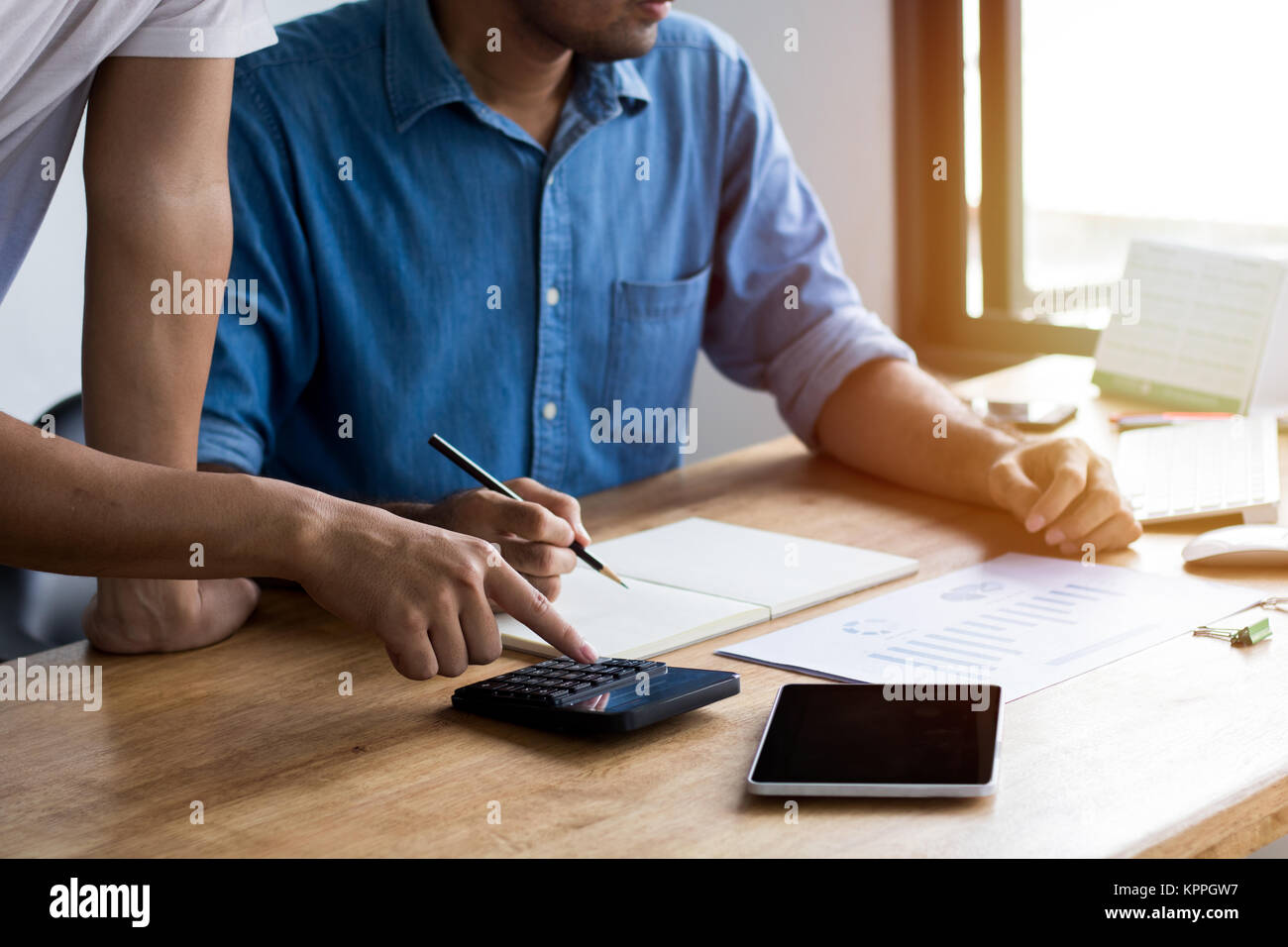 Berechnen budget Business Planung Konzept, zwei Menschen couting Einnahmen und Ausgaben durch den Einsatz von Taschenrechner und Papier Grafik auf Schreibtisch in Home Stockfoto