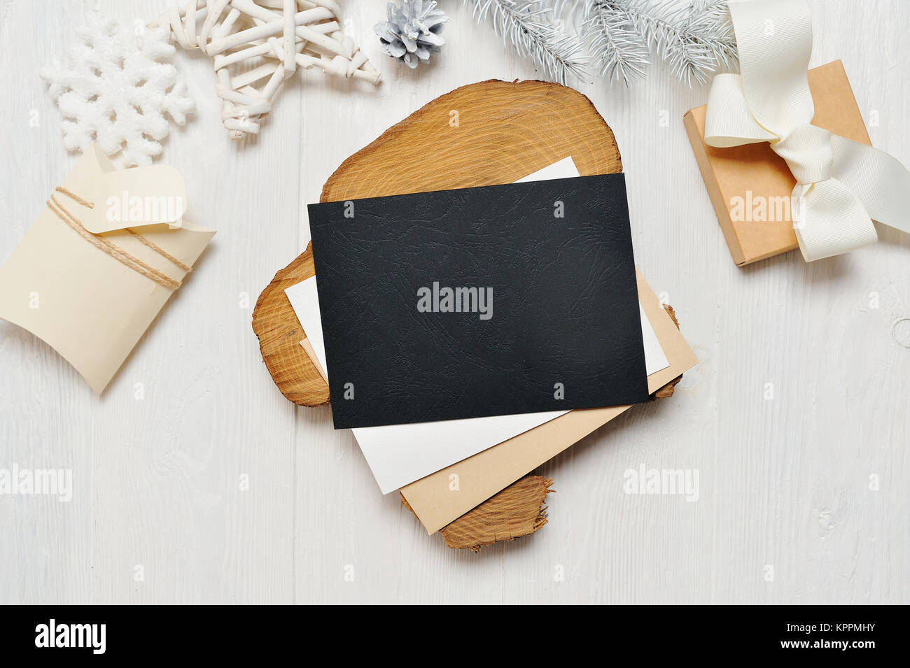Mockup Weihnachten schwarz Grußkarte Brief im Umschlag und Geschenk mit weißen Baum, flatlay auf einem weißen Hintergrund, aus Holz mit Platz für Ihren Text Stockfoto