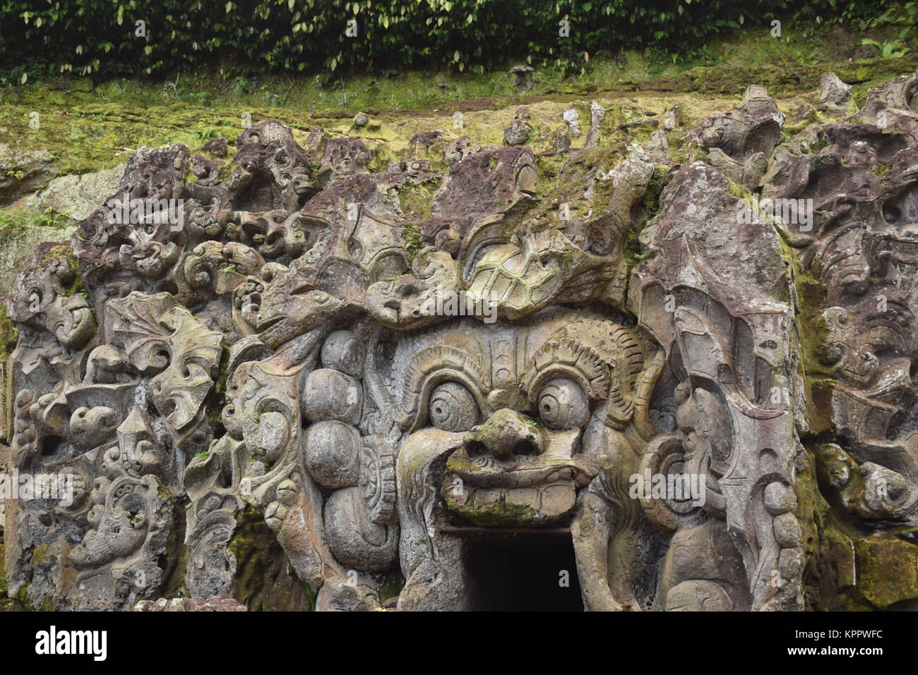 Der Eingang von Goa Gajah Heiligtum (auch "Elephant Cave) mit verschiedenen bedrohlichen Kreaturen und Dämonen in den Fels gehauen auf Bali - Indonesien Stockfoto