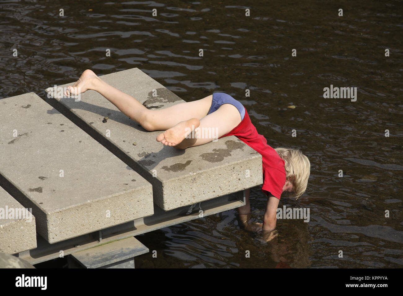 Bronchial-, Bergischen Land, Muengsten, Junge lag auf einem bootssteg an der Wupper. Deutschland, Bergisches Land, Muengsten, Junge spielt eine Stockfoto