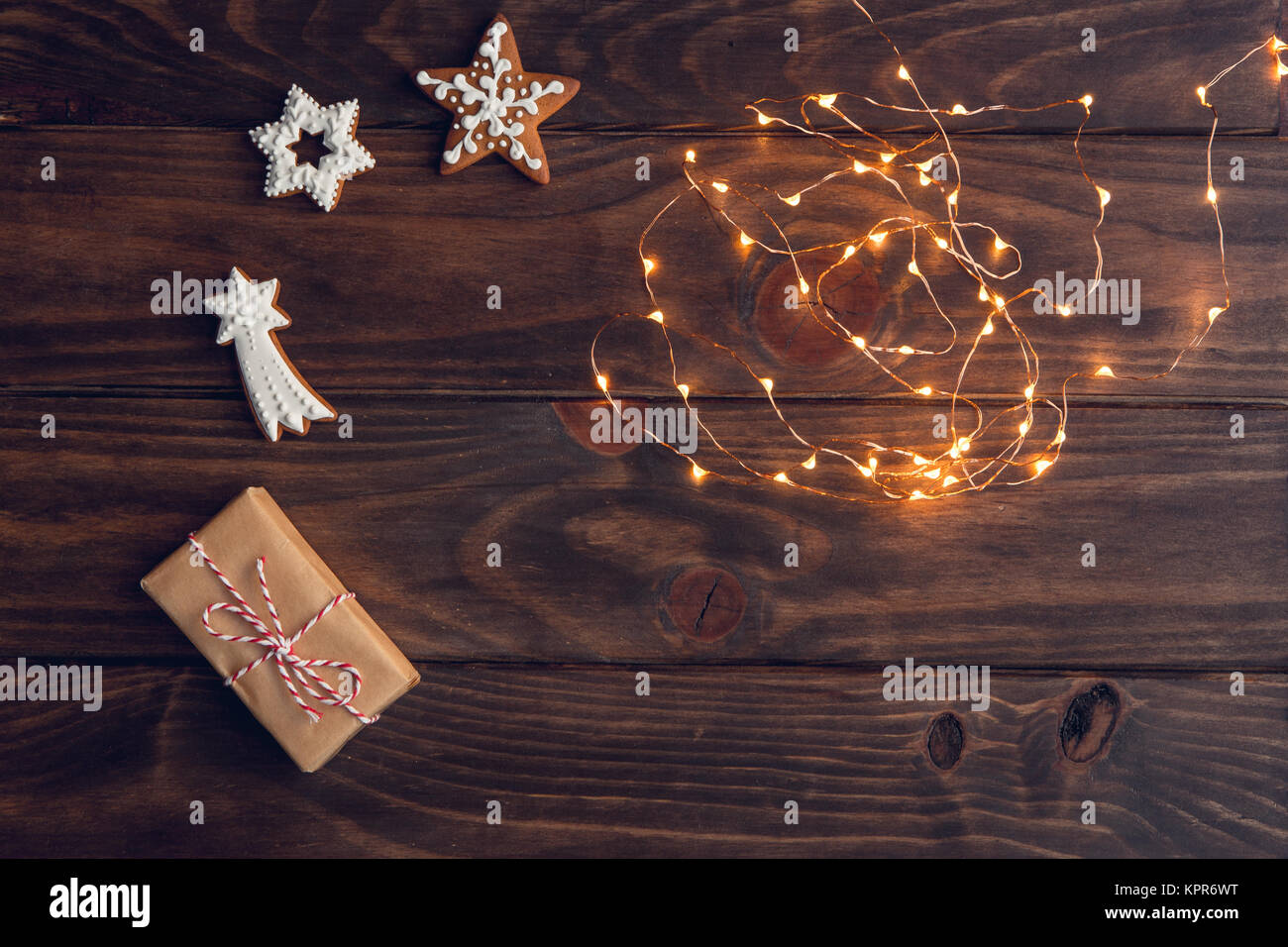 Weihnachten Geschenk, dekorierte Lebkuchen Kekse, gebratene orange Scheiben, Muttern, Zimt, Anis auf Holz Fach über dem alten Holztisch, von festlich dekoriert d Stockfoto