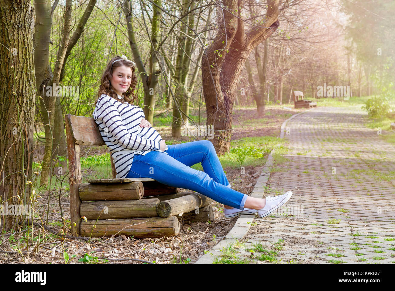 Schöne schwangere Frau Outdoor im Park auf banch Stockfoto