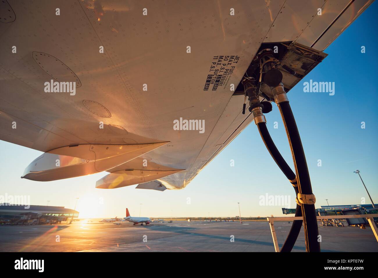 Sonnenuntergang am Flughafen. Die Betankung des Flugzeuges vor dem Flug. Stockfoto
