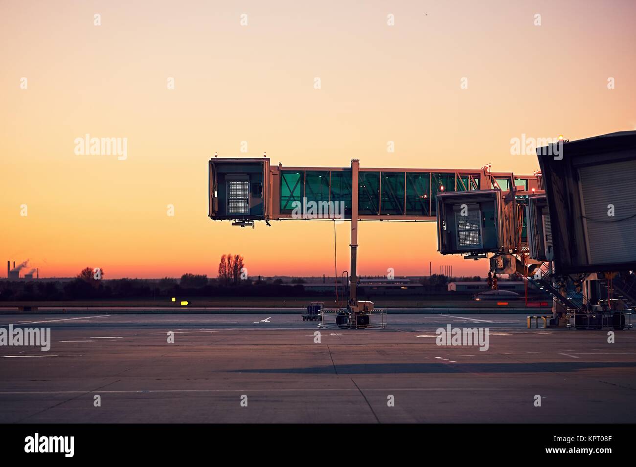 Leere Fluggastbrücken. Flughafen in der bunten Sonnenuntergang. Stockfoto