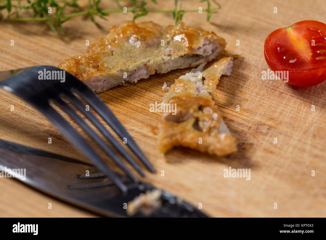 Gehirn Schweineschnitzel auf Holz Schneidebrett mit Cherry Tomaten und Thymian im Hintergrund Stockfoto