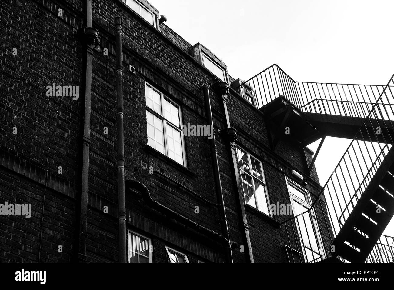 Schwarz-weiß Bild von einer externen Metalltreppe für Notausgänge aus einem Gebäude verwendet Stockfoto
