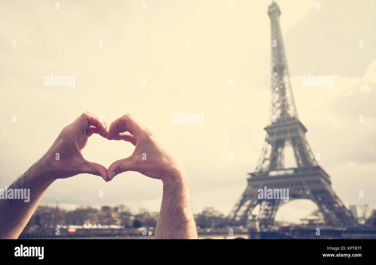 Liebe in Paris die Hände bilden ein Herz Form vor dem Eiffelturm
