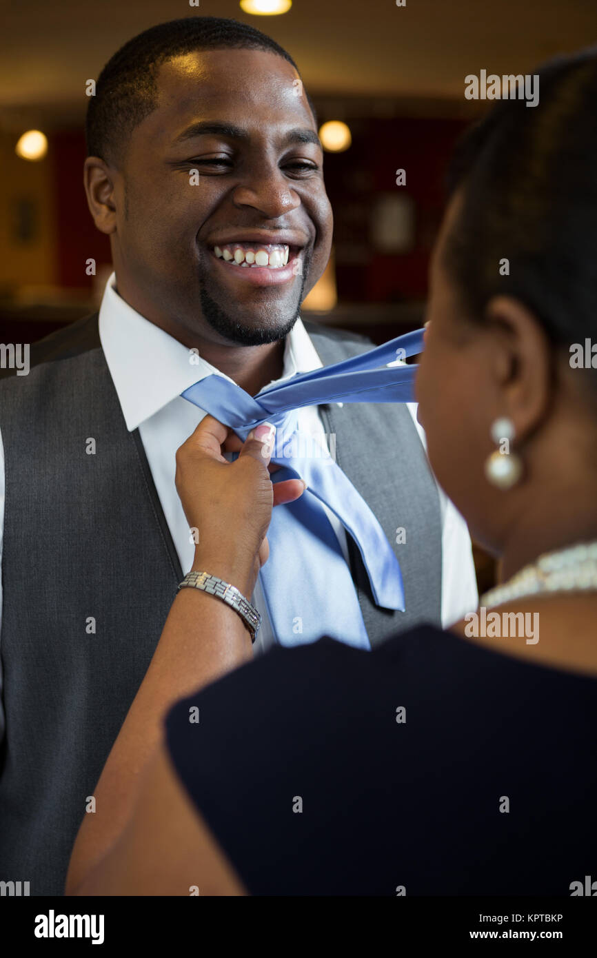 Die Mutter ihrem Sohn seine Krawatte binden helfen. Stockfoto
