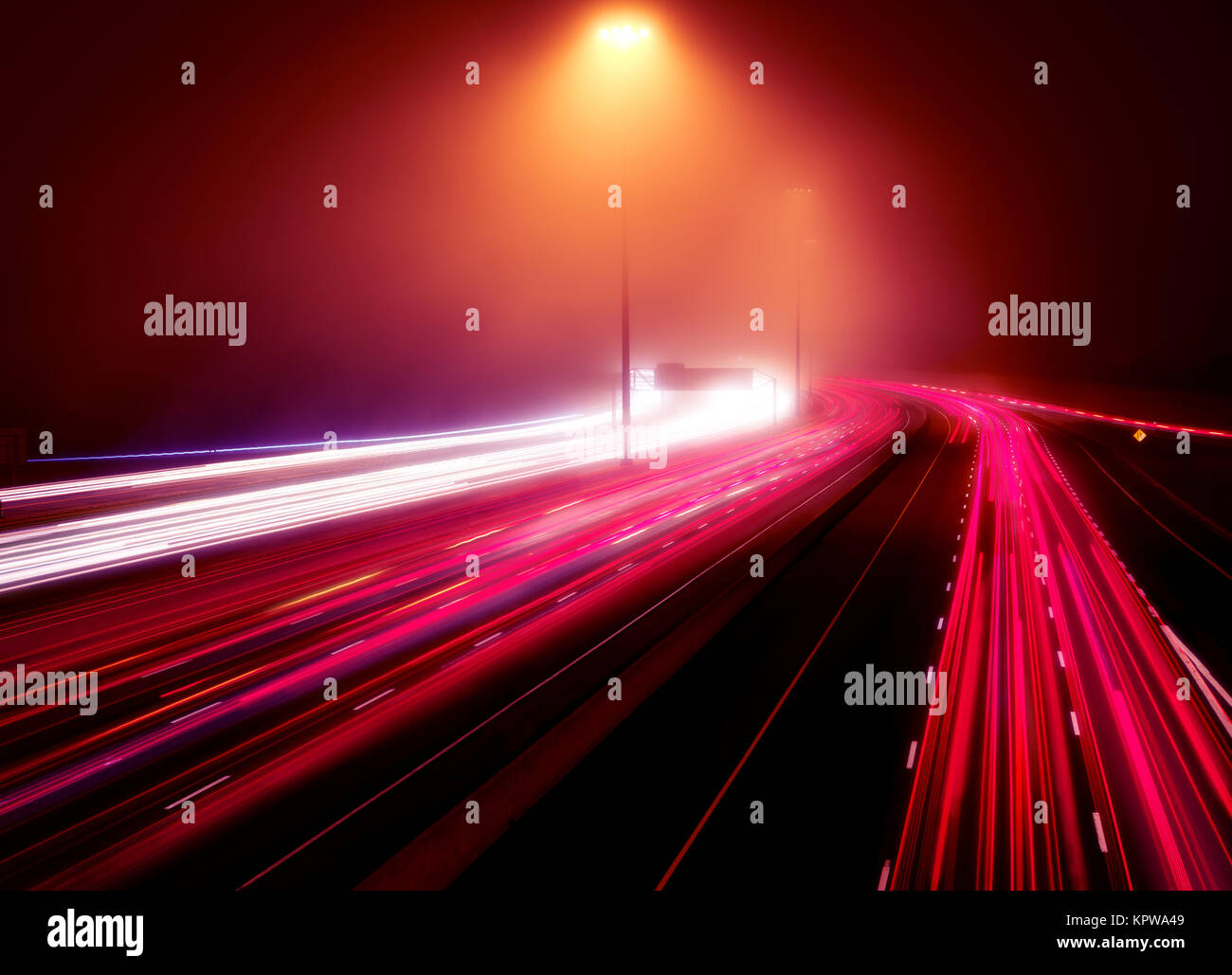 Künstlerische abstrakte Ampel Spuren an einem viel befahrenen Highway in der rush hour auf einem nebligen Nacht, Highway 401, Toronto, Ontario, Kanada. Stockfoto