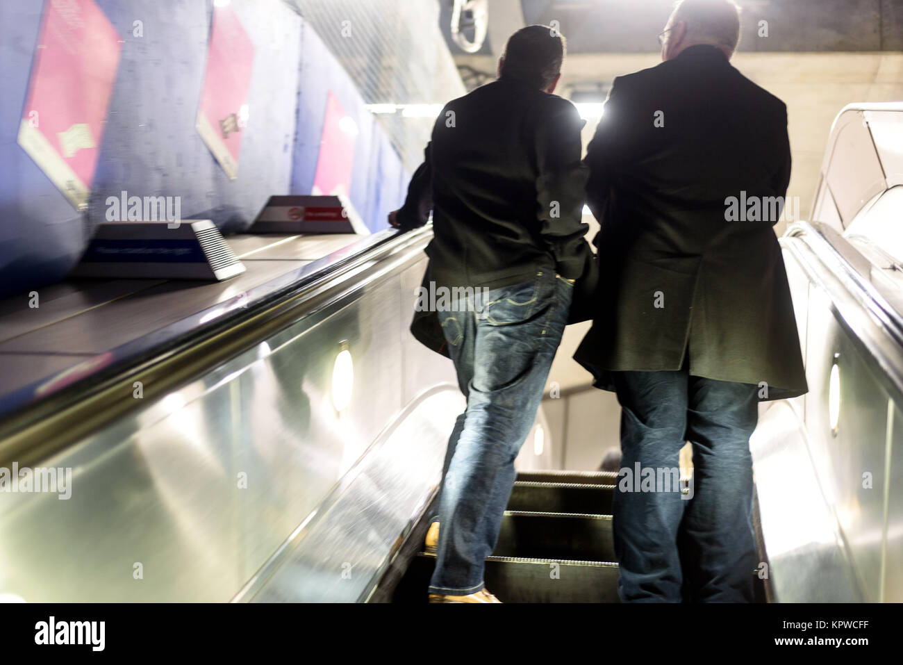 Zwei Männer mit der Londoner U-Bahn Fahrtreppen mit absichtlich verschwommene Bewegung und Bewegung Stockfoto