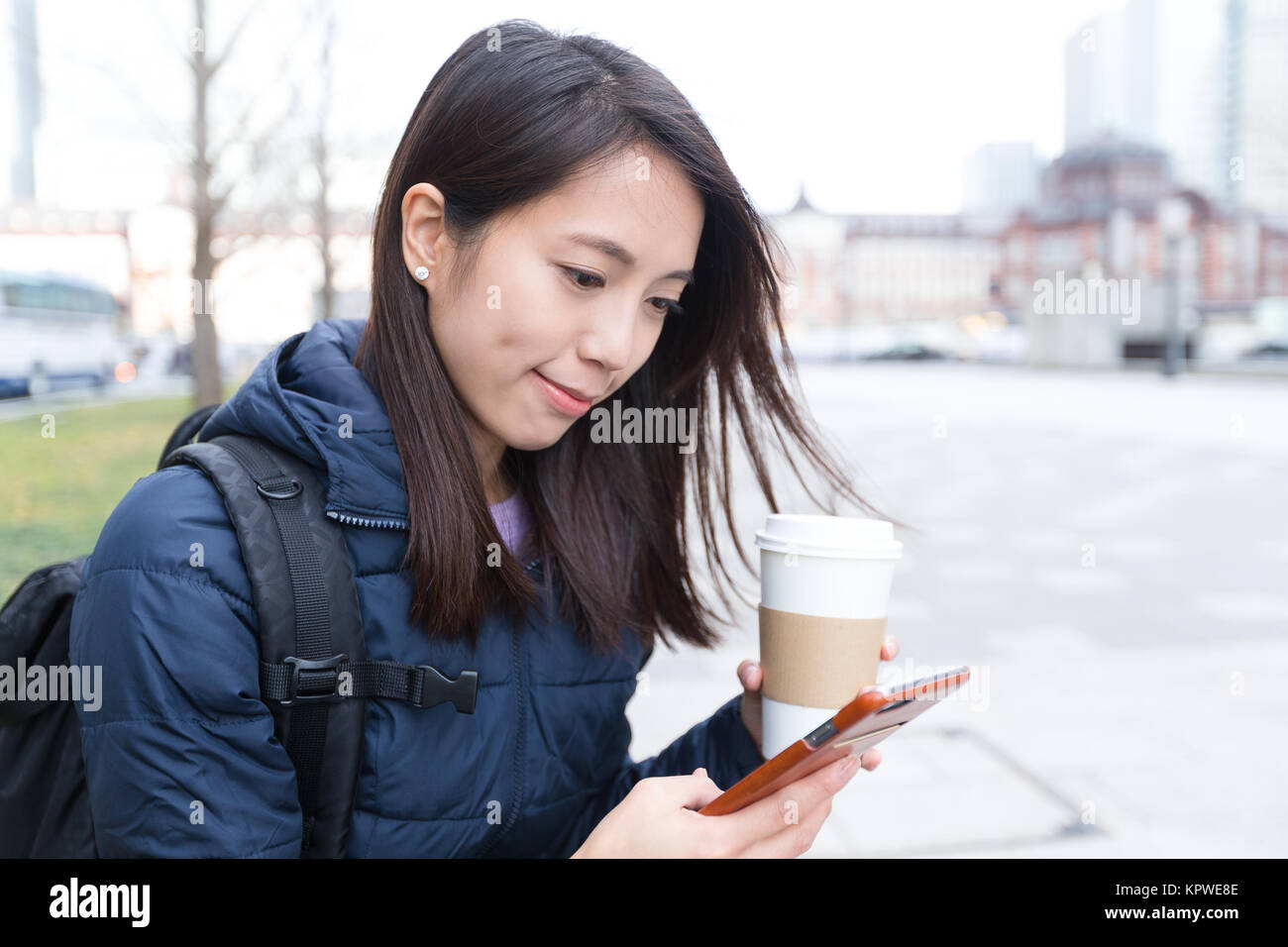 Frau Verwendung von Handys und Trinken von Kaffee Stockfoto