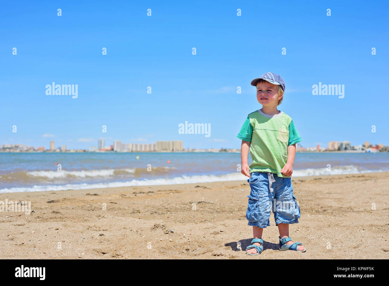 Niedliche kleine Junge stand am Strand Stockfoto