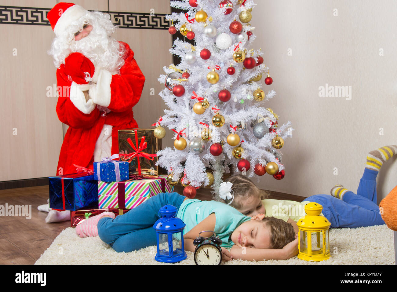 Der Weihnachtsmann brachte Geschenke für Silvester und weiche Gesichter der beiden schlafenden Schwestern Stockfoto