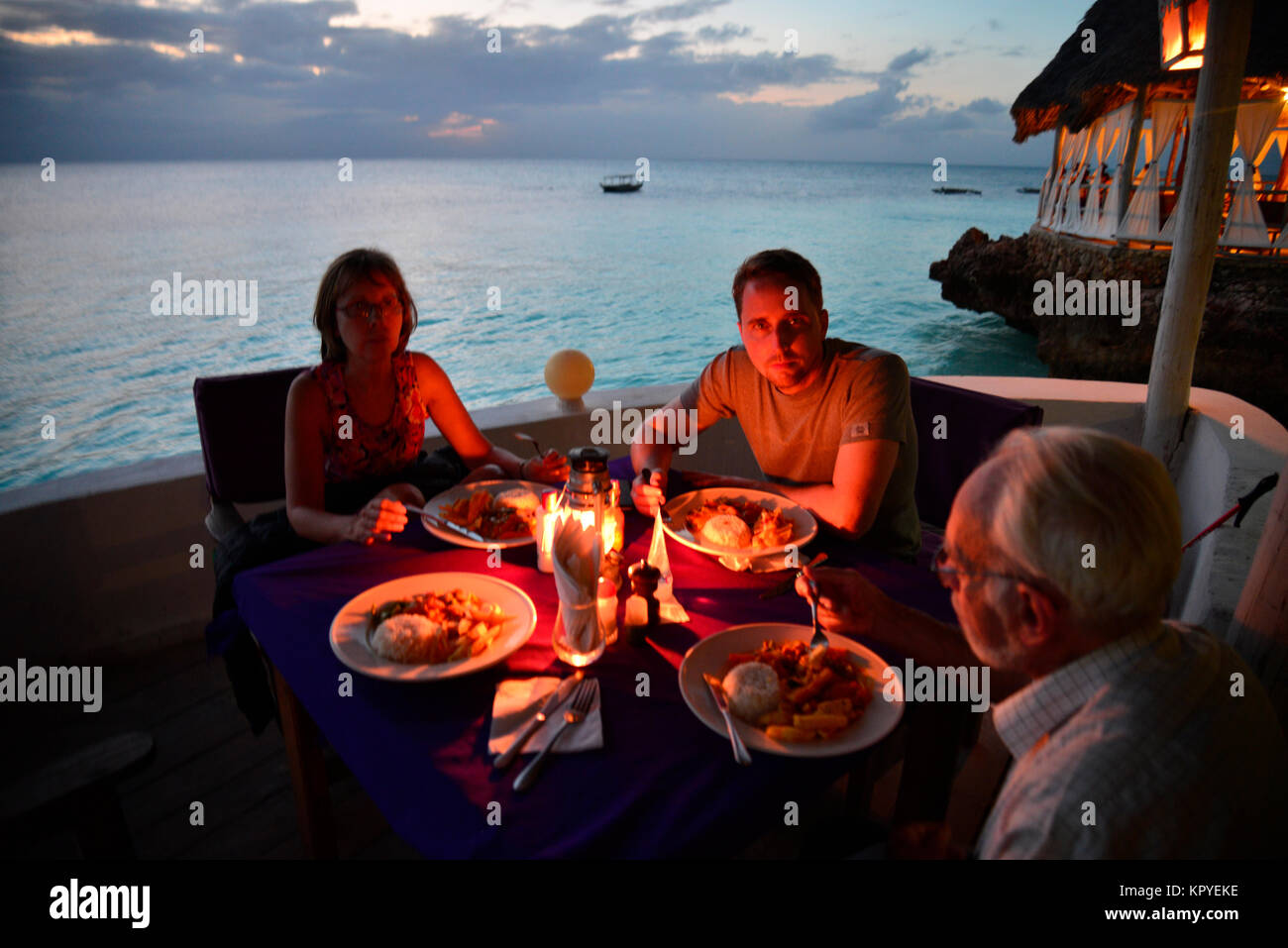 Sansibar ist eine Indische Ozean Paradies, das die meisten Menschen es sich leisten können, für faule Ferien auf warmen Strände zu besuchen. Abendessen bei Kerzenschein am Strand. Stockfoto