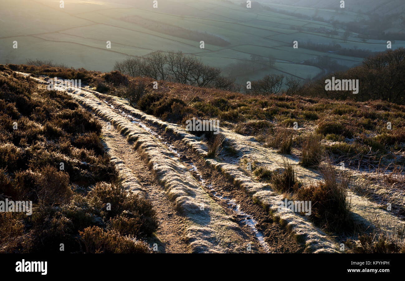 Frosty Fußweg in den Hügeln über Hayfield im Peak District. Hellen morgen Sonnenschein. Stockfoto