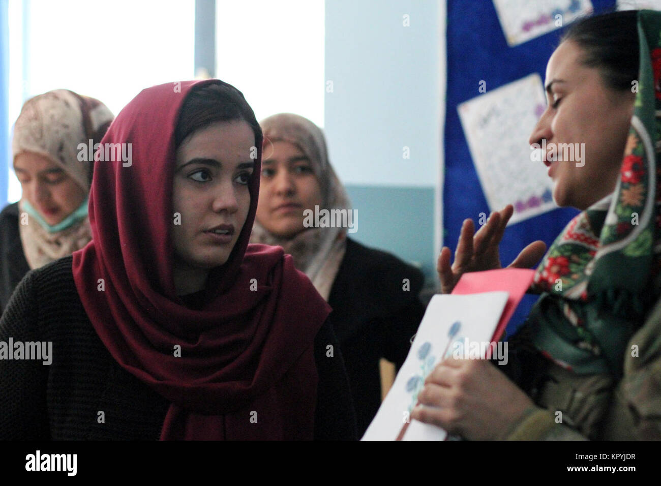 Afghanische junge Frauen Line up School Supplies während der Afghan National Army Special Operations Command Besuch der afghanischen Frauen Education Center in der Nähe von Camp Commando, Kabul, Afghanistan, Dez. 13, 2017 zu erhalten. (U.S. Armee Stockfoto