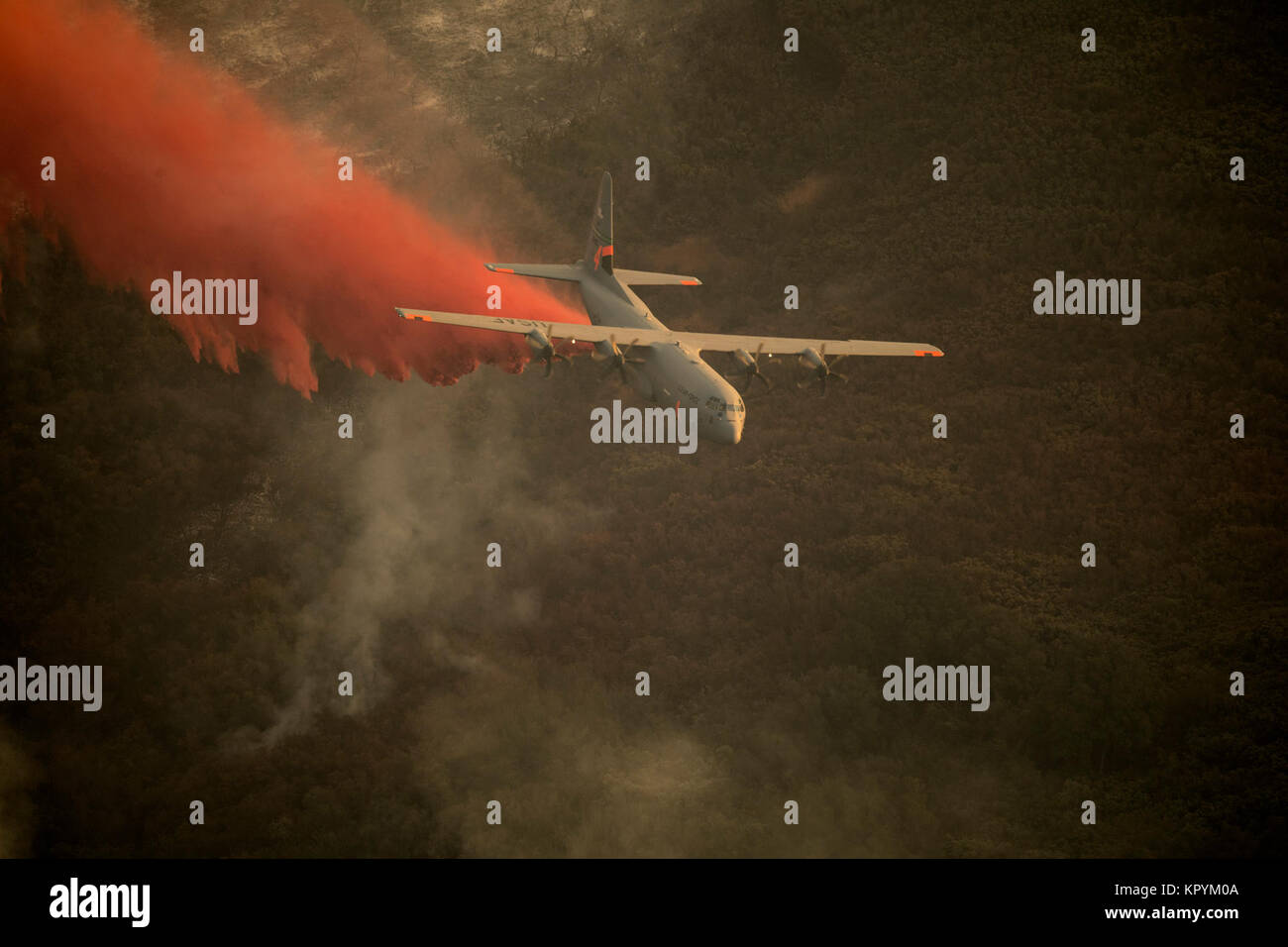 Ein US Air National Guard C-130J mit der MAFFS 2 (Modular luftgestützten Brandbekämpfung System) fällt eine Linie der Phos-Chek auf der Thomas Brand in den Hügeln oberhalb der Stadt Santa Barbara Dez. 13, 2017. Die C-130J von der 146 Luftbrücke Flügel hat die CAL's Feuer Bemühungen der Thomas Brand im südlichen Kalifornien raging zu kämpfen. (U.S. Air National Guard Stockfoto