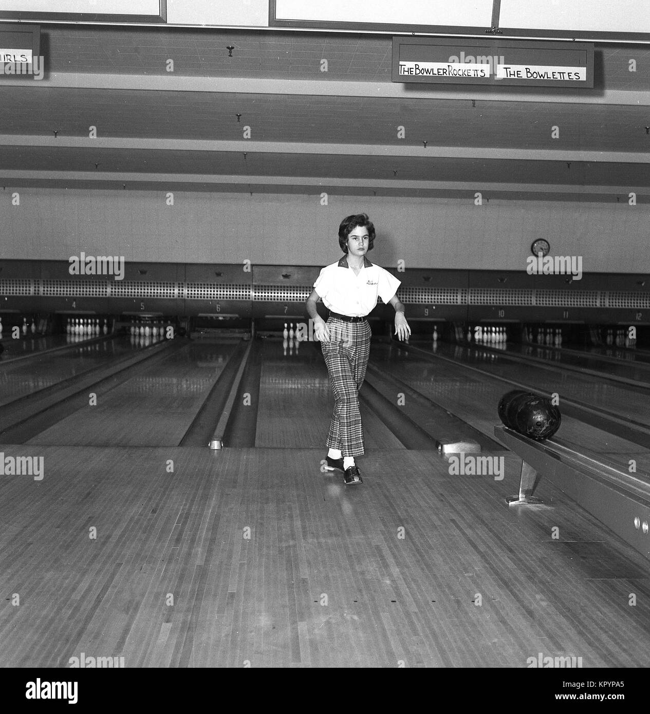 1960er Jahre, eine junge Dame in einem 10-pin Bowling Alley trägt eine typische Bowlers Outfit der Ära, USA. Stockfoto