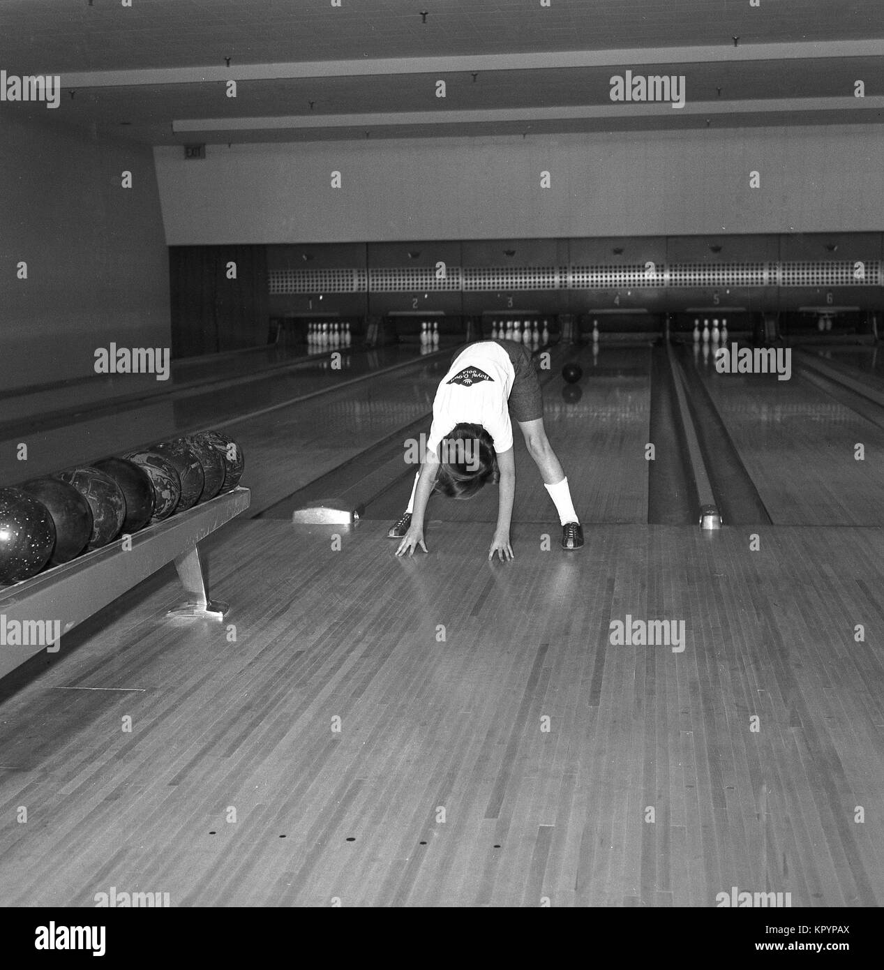 1960, historische, Bild zeigt ein weibliches Mitglied des "Royal Crown Cola "Ten-pin Bowling Team in einem 10-pin Bowling Alley eine Warm-up und Stretching vor der Teilnahme an einem Bowling Contest, USA. Stockfoto