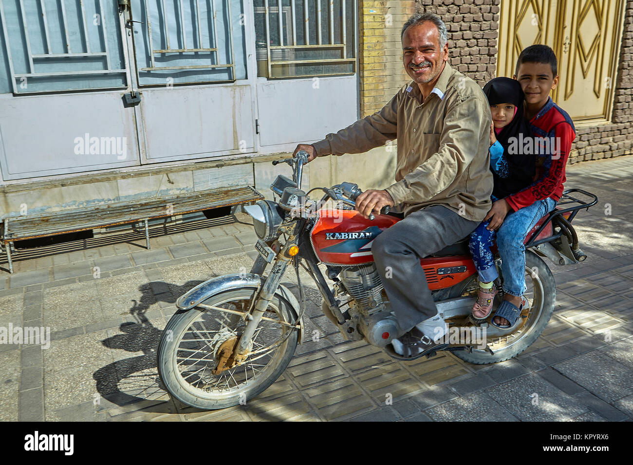 Yazd, Iran - 21. April 2017: Reifen iranischen Mann reitet ein Motorrad mit  seinen Kinder, Junge und Mädchen im Hijab Stockfotografie - Alamy