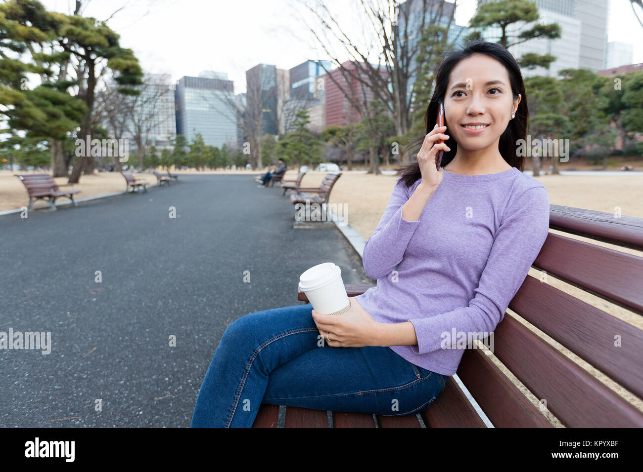 Frau chat auf Handy im Green Park Stockfoto